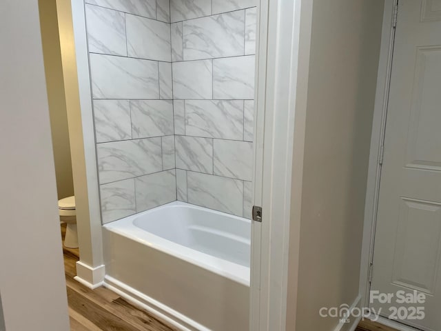 216 N Vance St, Gastonia, NC 28052 - bathroom featuring toilet, wood finished floors, baseboards, and shower / washtub combination