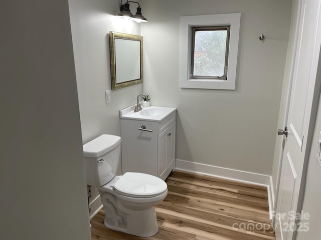216 N Vance St, Gastonia, NC 28052 - bathroom featuring vanity, wood finished floors, toilet, and baseboards