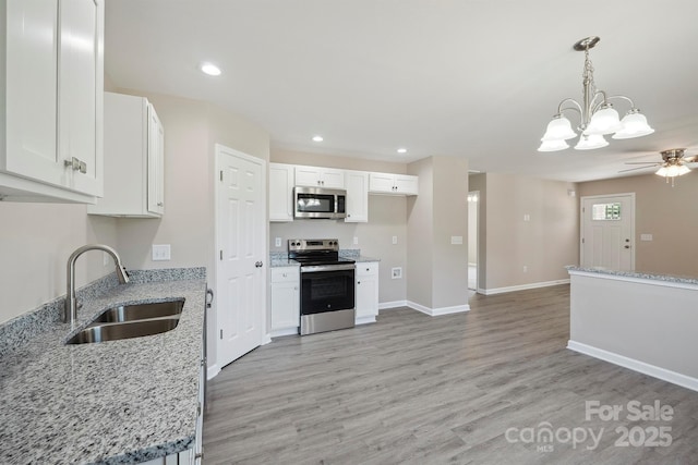528 S Caldwell St, Salisbury, NC 28144 - kitchen with stainless steel appliances, light wood-style floors, white cabinetry, recessed lighting, and light stone counters