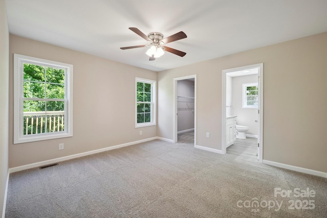 528 S Caldwell St, Salisbury, NC 28144 - unfurnished bedroom with carpet, a walk in closet, connected bathroom, a closet, and a ceiling fan