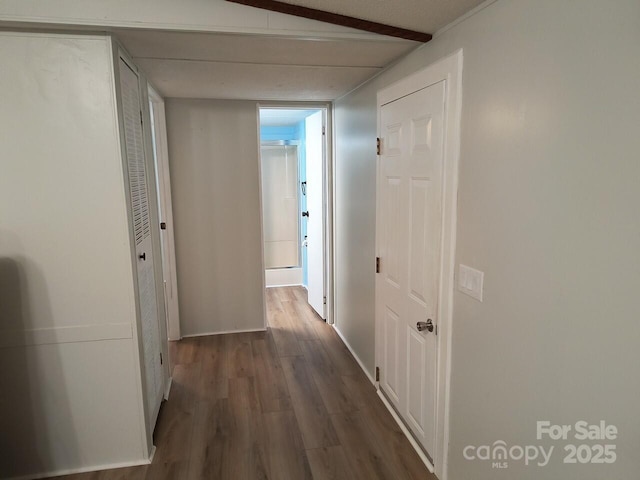 corridor featuring dark wood-style floors and baseboards