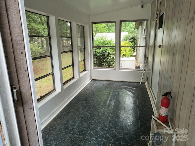 unfurnished sunroom featuring baseboards