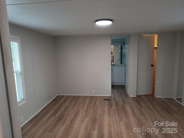 spare room featuring wood finished floors and baseboards