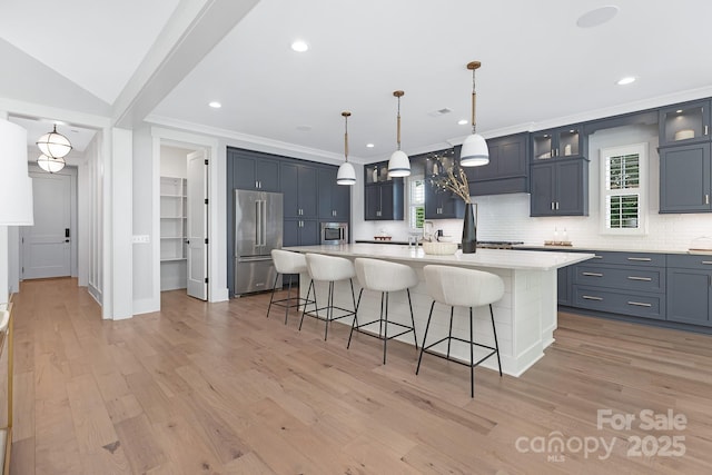 2026 Thatcher Way, Fort Mill, SC 29715 - kitchen with high end refrigerator, a breakfast bar area, light countertops, decorative backsplash, and a kitchen island with sink