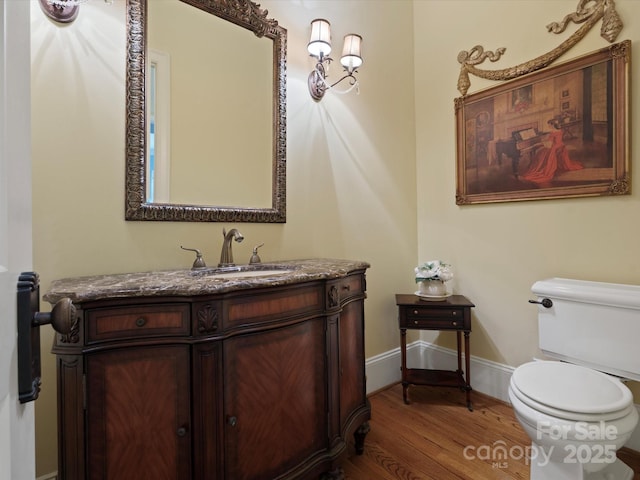 6742 Charlotte Hwy, York, SC 29745 - half bathroom featuring toilet, vanity, wood finished floors, and baseboards