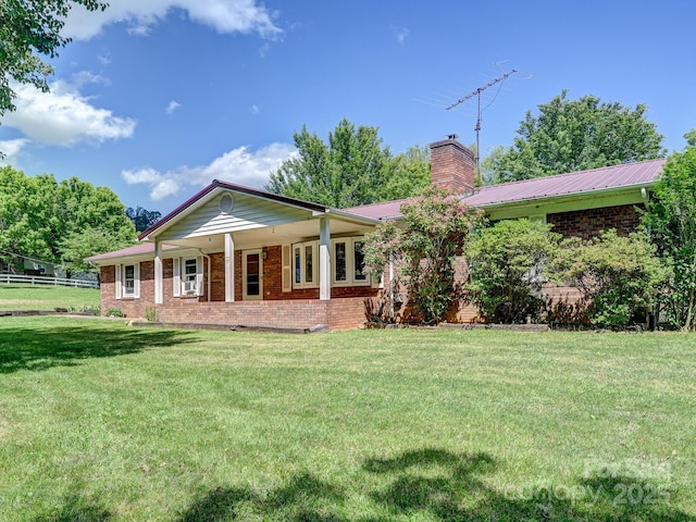 522 Bailey Mountain Rd, Mars Hill, NC 28754 - back of house featuring a chimney, brick siding, a lawn, and covered porch