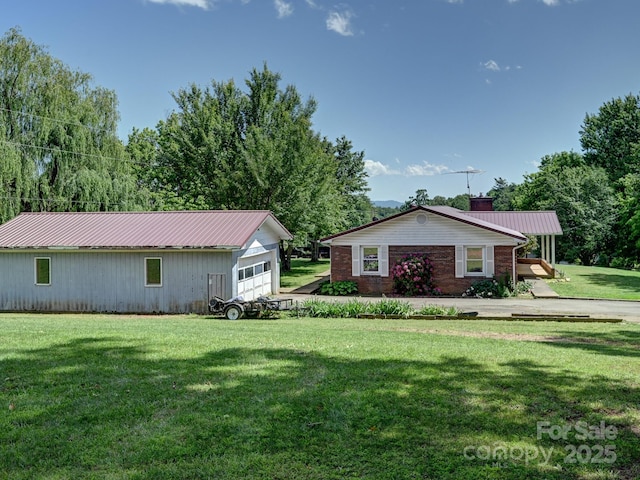 522 Bailey Mountain Rd, Mars Hill, NC 28754 - view of front of house with a chimney, a front yard, metal roof, a garage, and an outbuilding