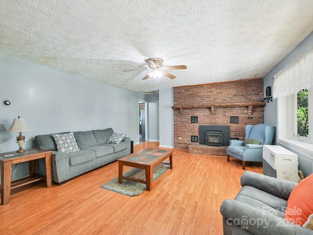 522 Bailey Mountain Rd, Mars Hill, NC 28754 - living room featuring wood finished floors, a ceiling fan, a textured ceiling, a brick fireplace, and baseboards