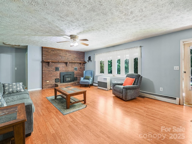 522 Bailey Mountain Rd, Mars Hill, NC 28754 - living area with a baseboard heating unit, a ceiling fan, light wood-style floors, a wood stove, and a textured ceiling