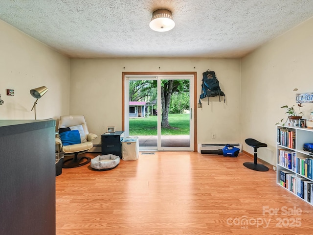 522 Bailey Mountain Rd, Mars Hill, NC 28754 - living area with wood finished floors, baseboard heating, a textured ceiling, a baseboard heating unit, and baseboards