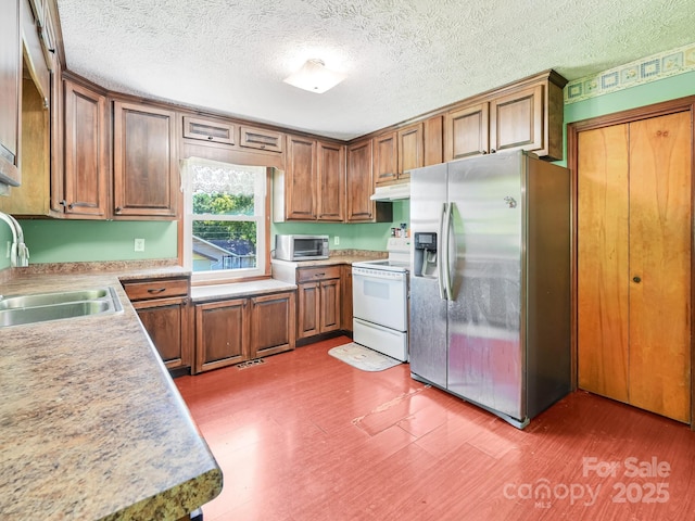 522 Bailey Mountain Rd, Mars Hill, NC 28754 - kitchen with stainless steel fridge, white electric stove, a sink, under cabinet range hood, and brown cabinets