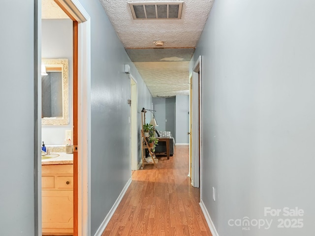 522 Bailey Mountain Rd, Mars Hill, NC 28754 - corridor featuring light wood-type flooring, a textured ceiling, and baseboards