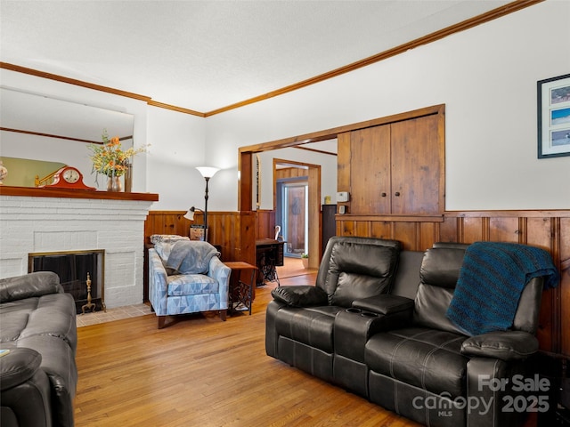 6 Woodley Ave, Asheville, NC 28804 - living room featuring wainscoting, crown molding, light wood finished floors, wooden walls, and a fireplace