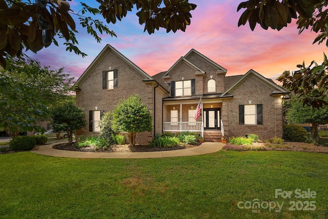389 Ponderosa Cir, Mooresville, NC 28117 - traditional-style house with a yard, brick siding, and covered porch