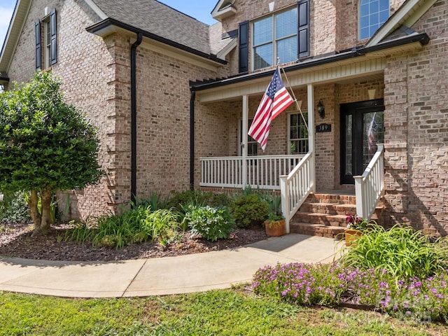 389 Ponderosa Cir, Mooresville, NC 28117 - doorway to property with a porch, brick siding, and a shingled roof