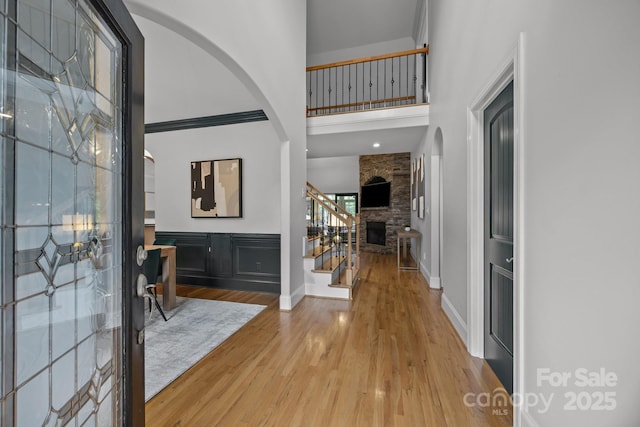 389 Ponderosa Cir, Mooresville, NC 28117 - foyer featuring a towering ceiling, wood finished floors, stairs, a fireplace, and arched walkways