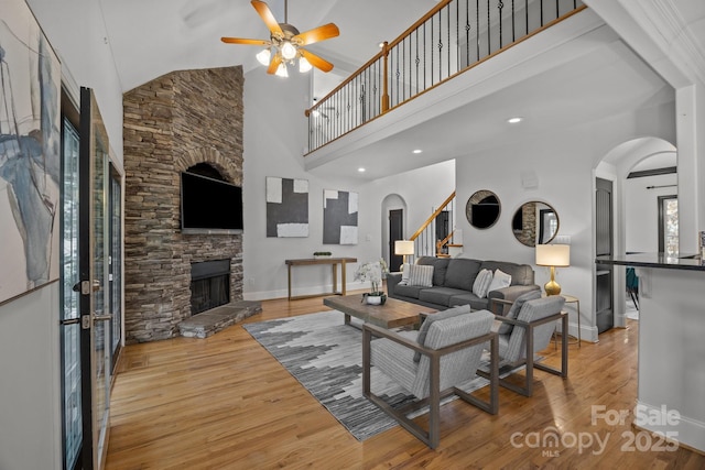 389 Ponderosa Cir, Mooresville, NC 28117 - living area featuring arched walkways, high vaulted ceiling, ceiling fan, wood finished floors, and a fireplace