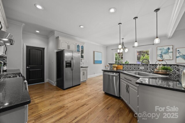 389 Ponderosa Cir, Mooresville, NC 28117 - kitchen featuring stainless steel appliances, a sink, ornamental molding, light wood-style flooring, and exhaust hood
