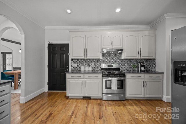 389 Ponderosa Cir, Mooresville, NC 28117 - kitchen with appliances with stainless steel finishes, under cabinet range hood, decorative backsplash, light wood finished floors, and crown molding