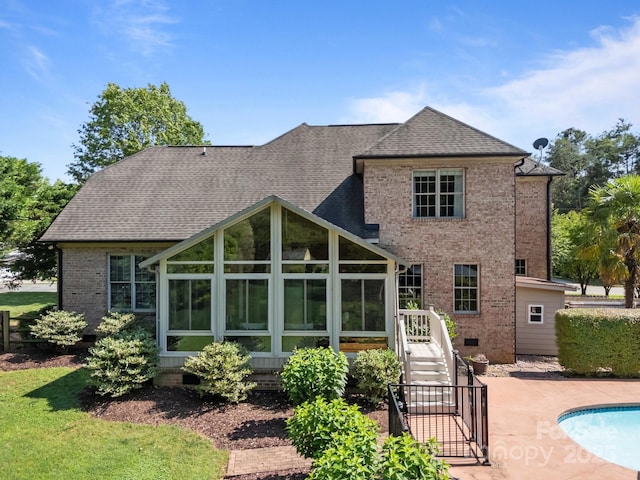 389 Ponderosa Cir, Mooresville, NC 28117 - rear view of property with a sunroom, brick siding, a patio area, an outdoor pool, and roof with shingles