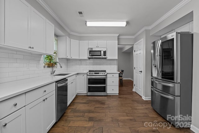 10327 Shelter Rock Ct, Charlotte, NC 28214 - kitchen with stainless steel appliances, a sink, white cabinetry, backsplash, and ornamental molding