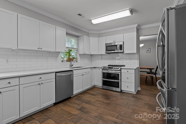 10327 Shelter Rock Ct, Charlotte, NC 28214 - kitchen with appliances with stainless steel finishes, a sink, crown molding, tasteful backsplash, and white cabinets