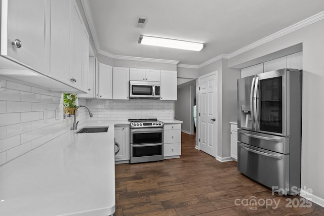 10327 Shelter Rock Ct, Charlotte, NC 28214 - kitchen with stainless steel appliances, a sink, ornamental molding, dark wood finished floors, and white cabinets