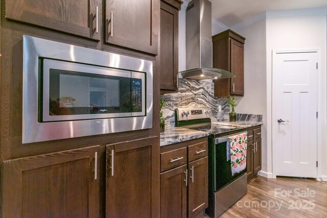 1811 Continental Dr, Albemarle, NC 28001 - kitchen with wall chimney exhaust hood, appliances with stainless steel finishes, decorative backsplash, light wood finished floors, and ornamental molding