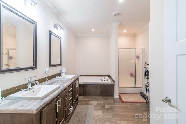 1811 Continental Dr, Albemarle, NC 28001 - bathroom featuring a stall shower, a garden tub, wood finished floors, ornamental molding, and double vanity