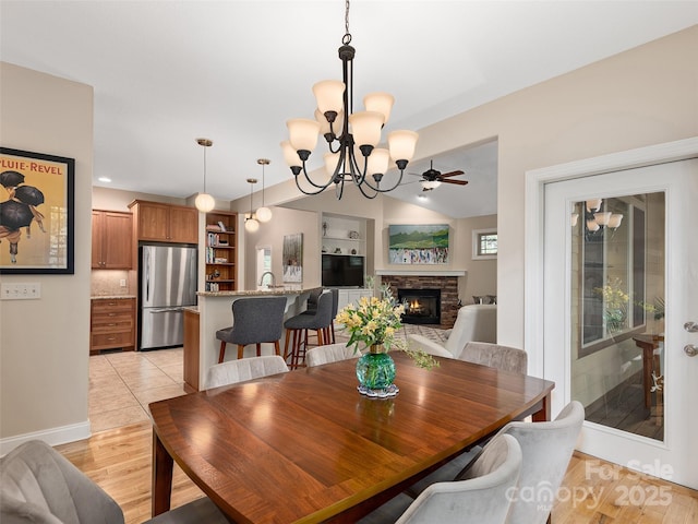 4 Alsatian Ln, Asheville, NC 28805 - dining space with a stone fireplace, a chandelier, light wood-style flooring, baseboards, and vaulted ceiling