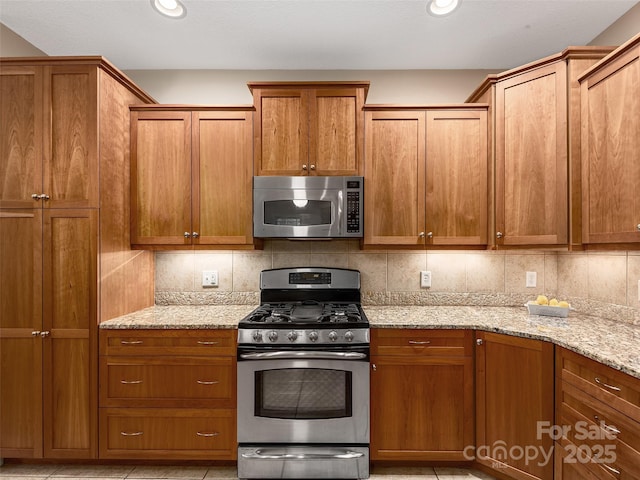 4 Alsatian Ln, Asheville, NC 28805 - kitchen with appliances with stainless steel finishes, backsplash, brown cabinets, light stone countertops, and recessed lighting