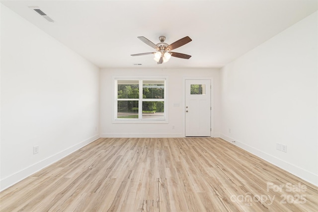 spare room with ceiling fan, baseboards, and light wood-style flooring