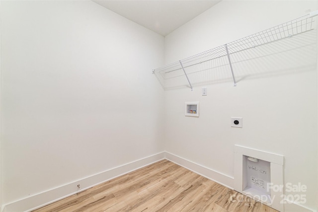 laundry area featuring washer hookup, light wood-type flooring, hookup for an electric dryer, and baseboards