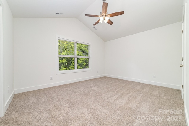 spare room featuring lofted ceiling, a ceiling fan, carpet flooring, and baseboards