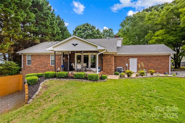 single story home with brick siding, a chimney, a patio area, and roof with shingles