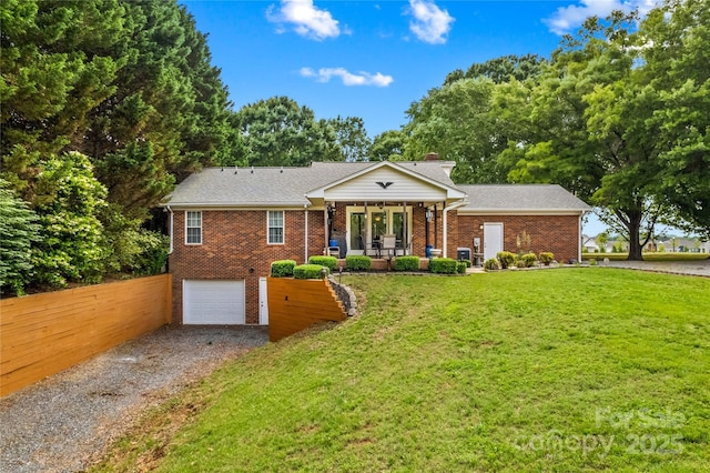 view of front of house featuring driveway, brick siding, covered porch, an attached garage, and a chimney
