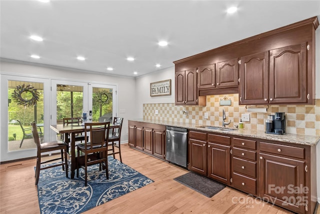 kitchen with a sink, stainless steel dishwasher, french doors, crown molding, and light wood-style floors