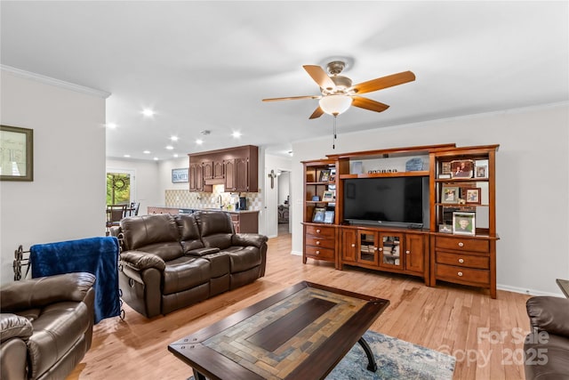 living area with a ceiling fan, light wood-style floors, crown molding, recessed lighting, and baseboards