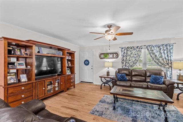 living area with ceiling fan, ornamental molding, light wood-style floors, and baseboards