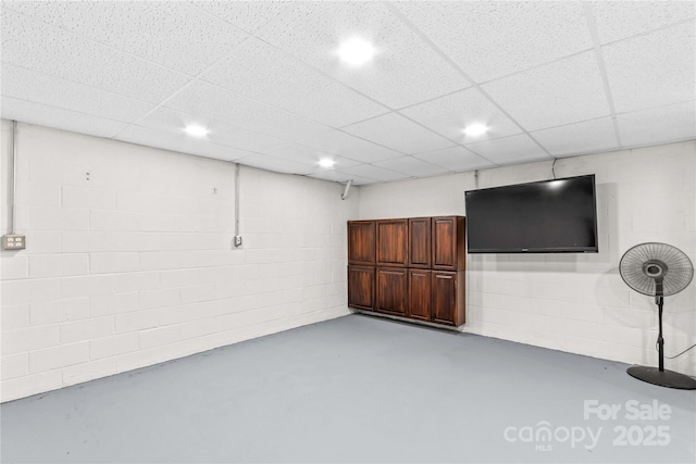 finished basement featuring recessed lighting, concrete block wall, and a drop ceiling