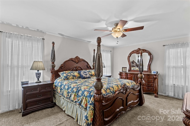 carpeted bedroom featuring crown molding and ceiling fan