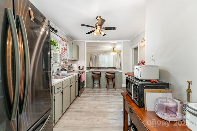 107 Oakland Rd, Belmont, NC 28012 - kitchen featuring appliances with stainless steel finishes, a sink, a ceiling fan, light wood-style floors, and light countertops