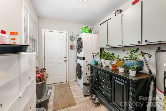 107 Oakland Rd, Belmont, NC 28012 - laundry room featuring stacked washer and clothes dryer, water heater, light wood finished floors, and cabinet space