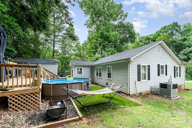 107 Oakland Rd, Belmont, NC 28012 - rear view of property with a wooden deck, an outdoor pool, cooling unit, a lawn, and view of scattered trees