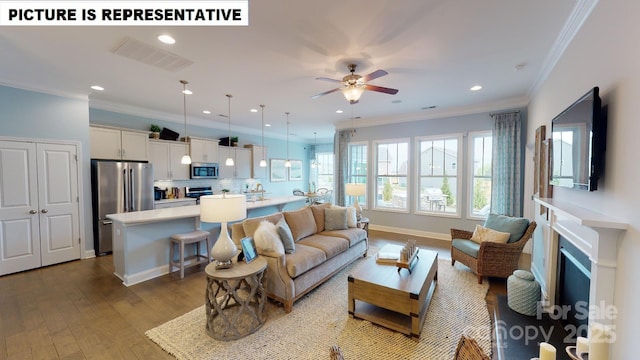 living area featuring a ceiling fan, wood finished floors, recessed lighting, crown molding, and a fireplace