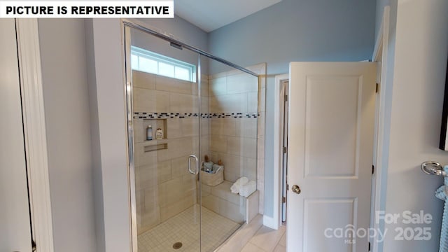 bathroom with a stall shower and tile patterned flooring