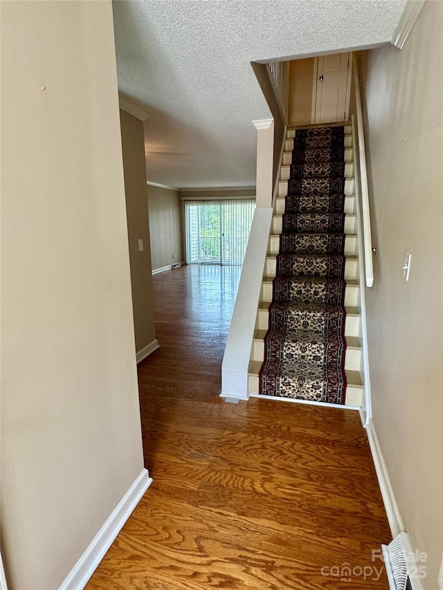 303 Eastwood Dr, Salisbury, NC 28146 - stairway featuring wood finished floors, baseboards, a textured ceiling, and ornamental molding