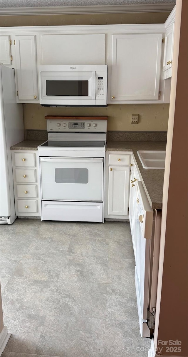 303 Eastwood Dr, Salisbury, NC 28146 - kitchen featuring white appliances, a sink, dark countertops, and white cabinetry
