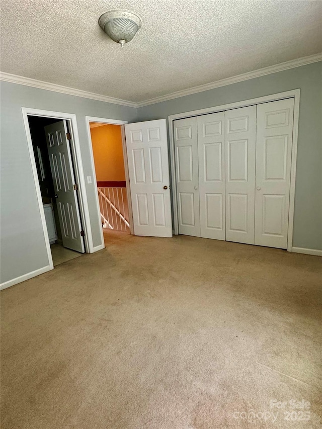 303 Eastwood Dr, Salisbury, NC 28146 - unfurnished bedroom featuring crown molding, a closet, carpet floors, a textured ceiling, and baseboards