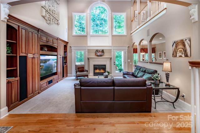 122 Sleepy Cove Trl, Mooresville, NC 28117 - living room featuring a high ceiling, a glass covered fireplace, baseboards, and carpet